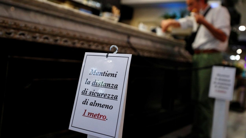 Un cartel en la barra de un bar en Roma pide que se guarde una distancia mínima de seguridad por la pandemia del coronavirus. REUTERS/Guglielmo Mangiapane