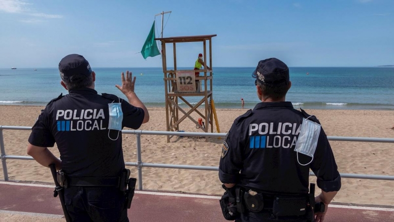 Efectivos policiales vigilan la playa de Can Pere Antoni de Palma. EFE/ CATI CLADERA