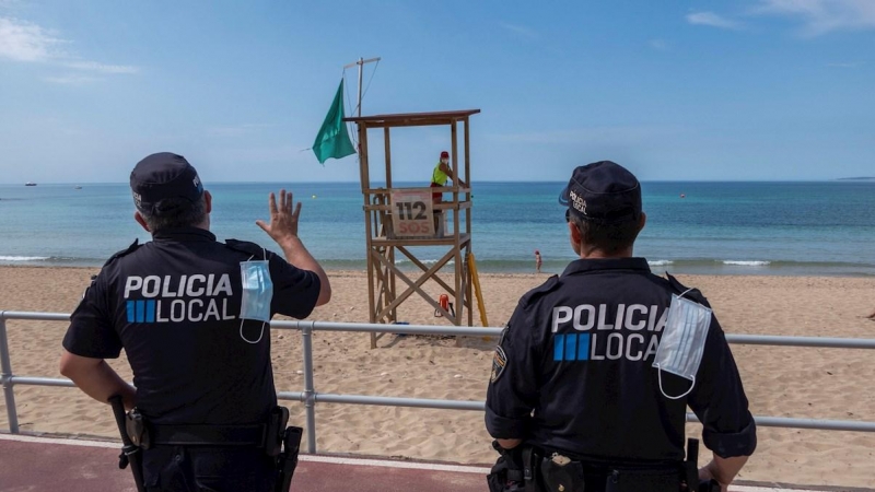 Efectivos policiales vigilan la playa de Can Pere Antoni de Palma. EFE/ CATI CLADERA