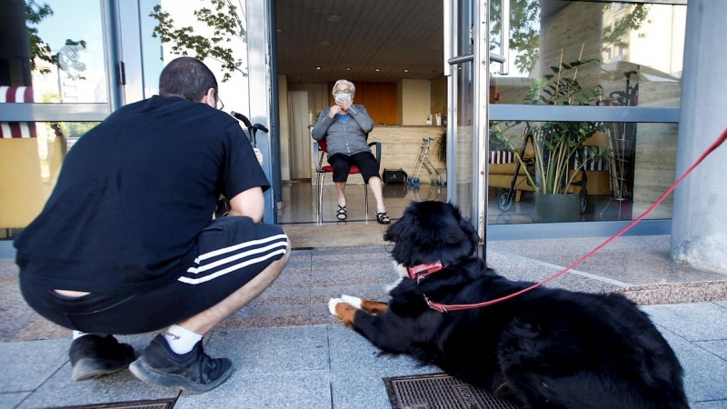 Sergi visita a su abuela Maria Llüisa, en la residencia geriátrica Icaria, del Barrio de Poble Nou de Barcelona a través de la puerta siguiendo las medidas de seguridad de la Fase 1 de desescalada este miércoles septuagésimo quinto día del estado de alarm