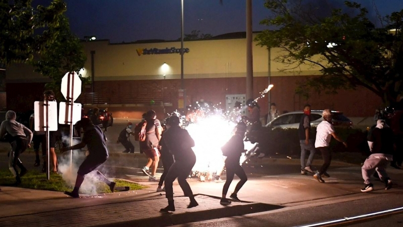 Una granada de aturdimiento lanzada por la policía detona para dispersar a los manifestantes que protestaban por la muerte de George Floyd. EFE / CRAIG LASSIG