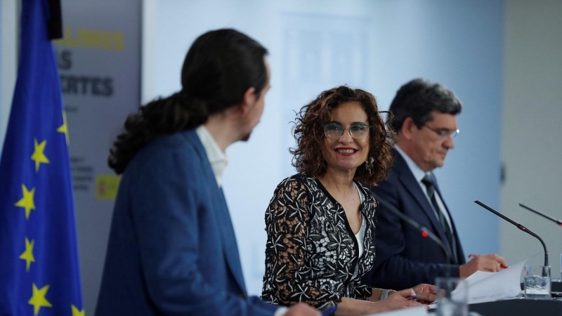 El vicepresidente segundo, Pablo Iglesias (i), la ministra de Hacienda y portavoz del Gobierno, María Jesús Montero (c), y el ministro de Inclusión, Seguridad Social y Migraciones, José Luis Escrivá (d), durante  la rueda de prensa tras el Consejo de Mini