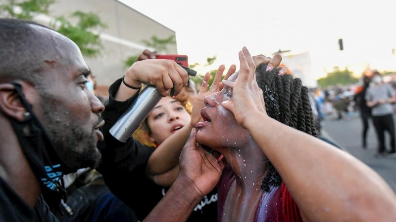 31/05/2020.- Un manifestante se limpia los ojos tras ser rociada con un spray por la policía durante las manifestaciones por quinto día consecutivo por la muerte de George Floyd en Minneapolis, Minnesota, Estados Unidos este domingo. EFE/ Craig Lassig