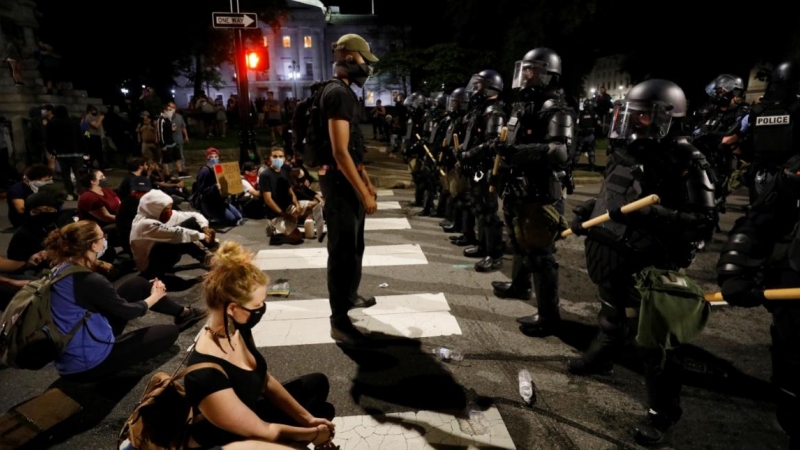 Un manifestante se enfrentará a policías antidisturbios durante los disturbios en todo el país tras la muerte de George Floyd, Carolina del Norte. REUTERS / Jonathan Drake