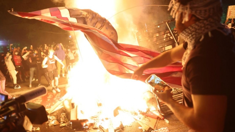 Los manifestantes queman una bandera estadounidense en una hoguera durante un mitin contra la muerte de George Floyd, en Washington, D.C. REUTERS / Jonathan Ernst
