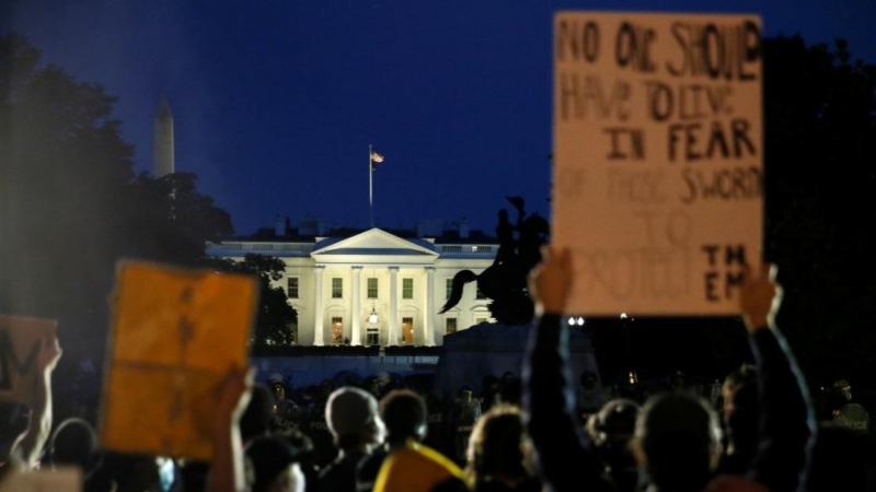 Los manifestantes sostienen carteles cerca de la Casa Blanca en Washington, durante una protesta en medio de disturbios en todo el país por la muerte de George Floyd en Minneapolis. REUTERS / Jim Bourg