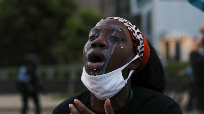 Una mujer con leche en la cara para tratar gases lacrimógenos durante las protestas por George Floyd en Minneapolis, Minnesota. REUTERS / Leah Millis