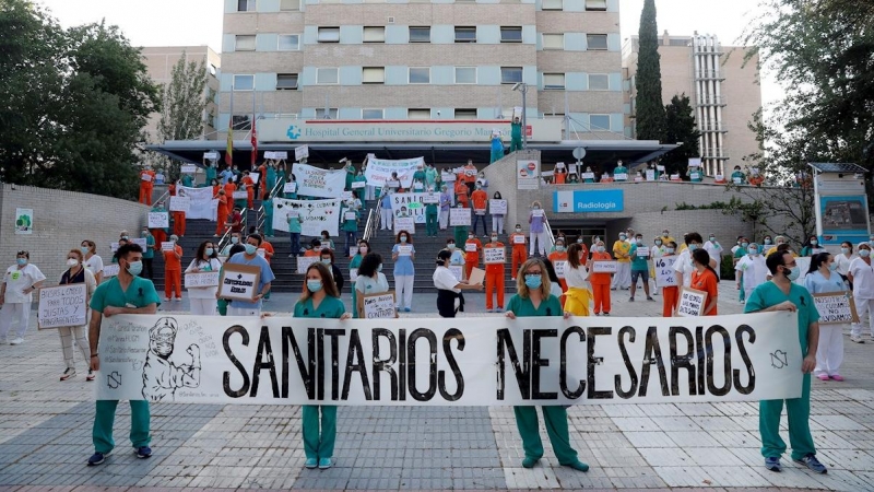 Miembros del personal sanitario del Hospital Gregorio Marañón posan con una pancarta en la que se lee 'Sanitarios necesarios' durante una concentración este lunes en el exterior del hospital en Madrid, en la primera jornada de la Comunidad en la fase 1 de
