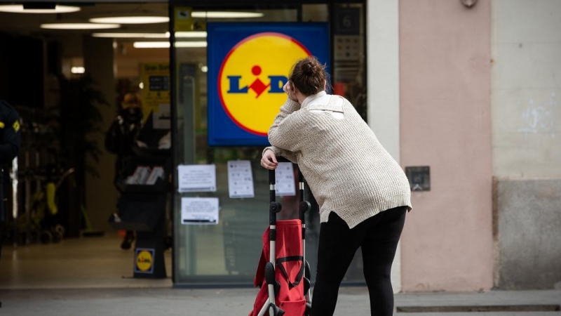Una mujer espera con su carro de la compra a poder entrar a un supermercado Lidl , en Barcelona. E.P./David Zorrakino