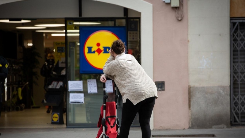 Una mujer espera con su carro de la compra a poder entrar a un supermercado Lidl , en Barcelona. E.P./David Zorrakino