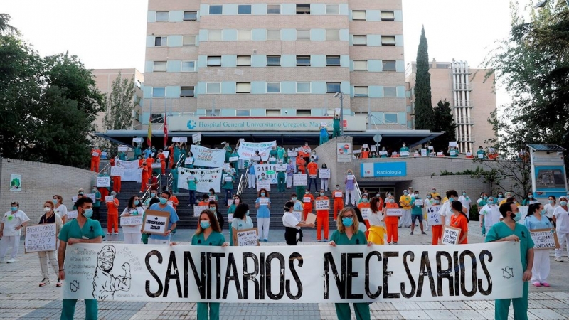 31/05/2020.- Miembros del personal sanitario del Hospital Gregorio Marañón posan con una pancarta en la que se lee ''Sanitarios necesarios'' durante una concentración este lunes en el exterior del hospital en Madrid, en la primera jornada de la Comunidad