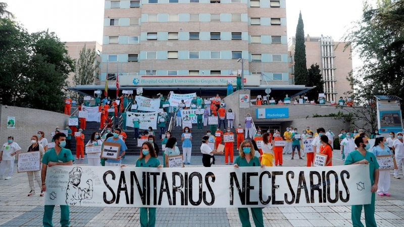 31/05/2020.- Miembros del personal sanitario del Hospital Gregorio Marañón posan con una pancarta en la que se lee ''Sanitarios necesarios'' durante una concentración este lunes en el exterior del hospital en Madrid, en la primera jornada de la Comunidad