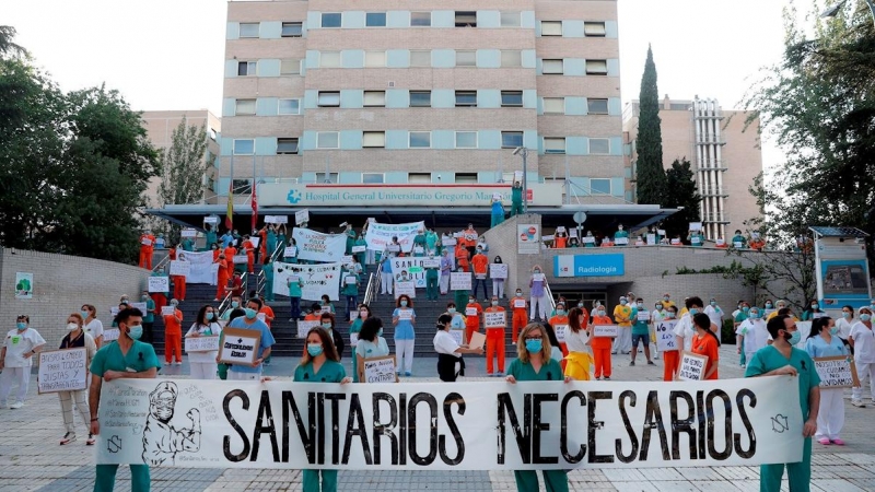 31/05/2020.- Miembros del personal sanitario del Hospital Gregorio Marañón posan con una pancarta en la que se lee ''Sanitarios necesarios'' durante una concentración este lunes en el exterior del hospital en Madrid, en la primera jornada de la Comunidad