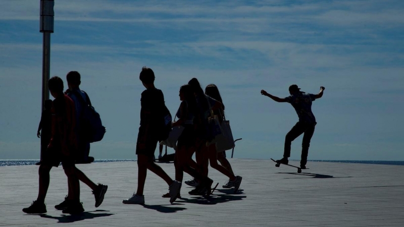 Un grupo de jóvenes caminan por la playa de la Barceloneta. - EFE