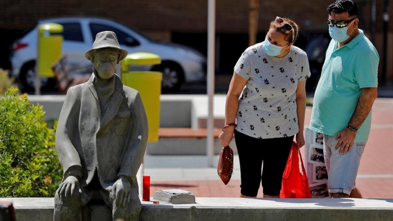 Dos personas observan una escultura, de autor desconocido, en la pedanía valenciana de Benimamet, en recuerdo a los fallecidos por la Covid-19. EFE/Manuel Bruque