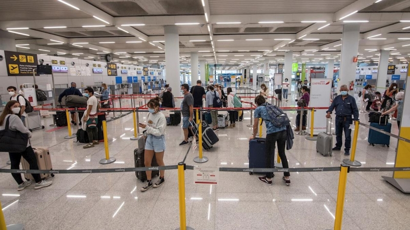 GRAF7750. PALMA DE MALLORCA, 08/06/2020.- Varios viajeros esperan para acceder a los mostradores de facturación en el aeropuerto de Palma de Mallorca este lunes, primer día en fase 3 que elimina restricciones el transporte aéreo y marítimo regular comerci