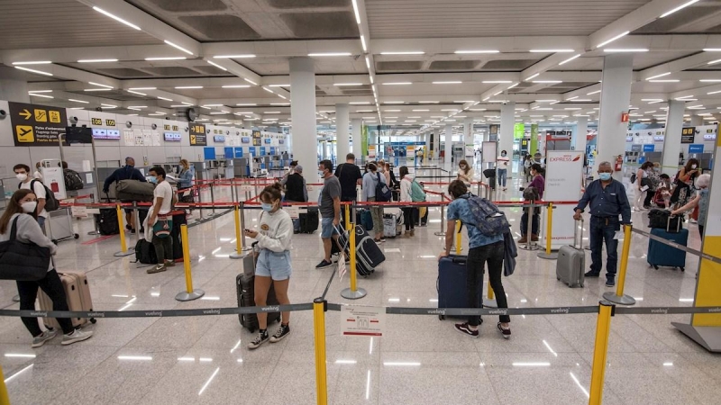 GRAF7750. PALMA DE MALLORCA, 08/06/2020.- Varios viajeros esperan para acceder a los mostradores de facturación en el aeropuerto de Palma de Mallorca este lunes, primer día en fase 3 que elimina restricciones el transporte aéreo y marítimo regular comerci