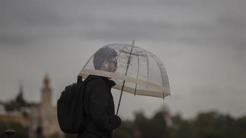 Un hombre camina bajo la lluvia protegido bajo su paraguas durante un chubasco. / Europa Press / Archivo
