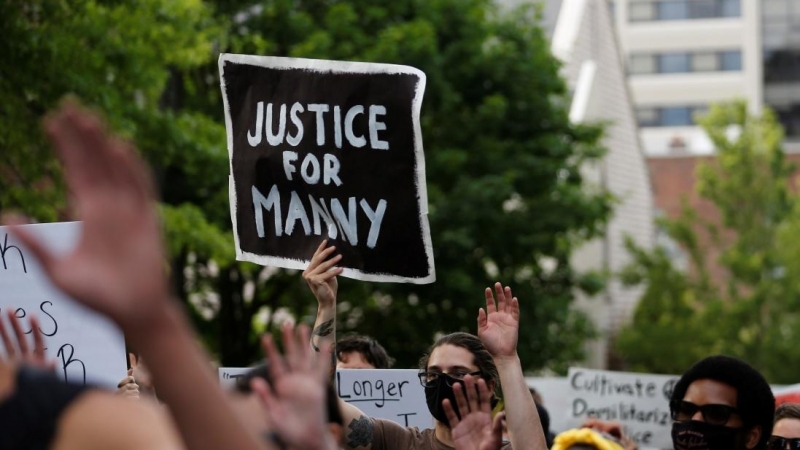 Un manifestante lleva un cartel de 'Justicia para Manny' en una protesta tras la muerte de Manuel Ellis en custodia policial en Tacoma en marzo. REUTERS / Lindsey Wasson