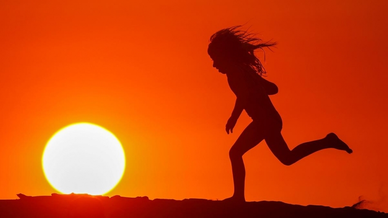 Un niño corre por la playa al atardecer durante en Carlsbad, California, EEUU.-REUTERS / Mike Blake