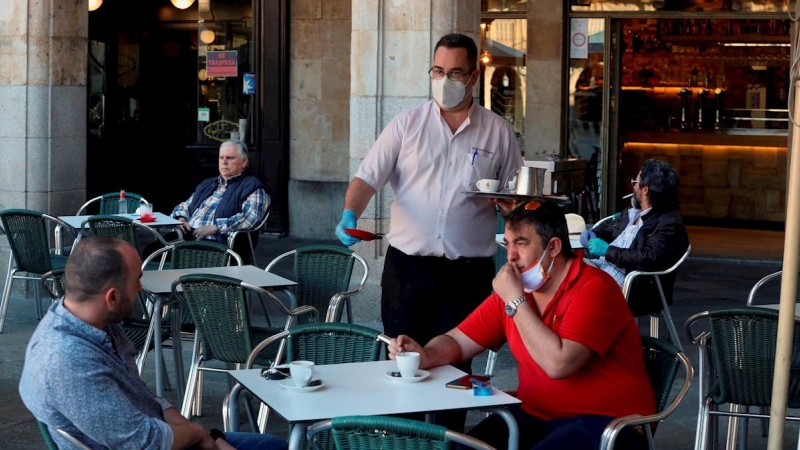 Un camarero sirve a los clientes en su bar de la Plaza Mayor de Salamanca. EFE/JM García