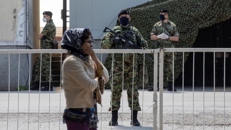Una mujer migrante pasa junto a un control militar.  -REUTERS/Marko Djurica