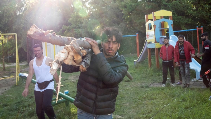 Un migrante transporta leña en el campamento de Principovac para migrantes cerca de Sid, Serbia. - REUTERS / Marko Djurica
