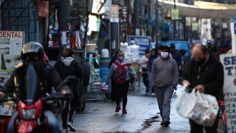 Personas pasean en la ciudad de Buenos Aires con mascarillas de protección.  REUTERS/Agustin Marcarian