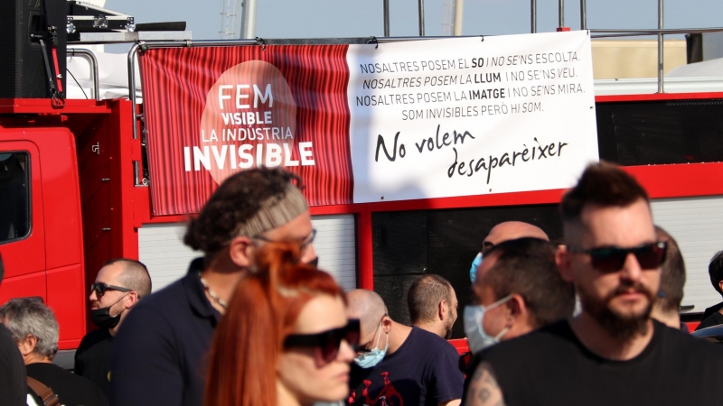 Convocatòria a l'aparcament del Palau Sant Jordi de la marxa lenta de vehicles per reclamar mesures per a la indústria de l'espectacle amb el cartell al fons 'Fem visible la indústria de l'invisible'. MAR VILA / ACN