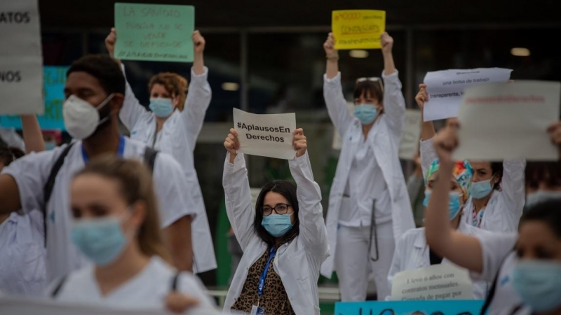 Decenas de miembros del personal sanitario protegidos con mascarilla sostienen carteles durante la concentración de sanitarios en el Día Internacional de la Enfermería a las puertas del Hospital Vall d'Hebron, en Barcelona. Europa Press / Archivo
