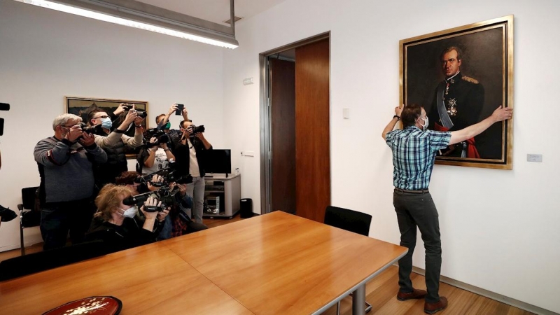 Un empleado del Parlamento de Navarra retira de la 'sala de gobierno' el retrato de Juan Carlos de Borbón. - EFE