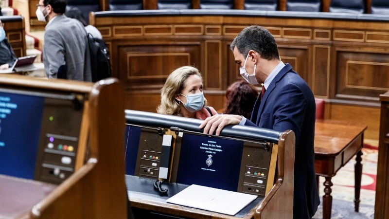 El presidente del Gobierno, Pedro Sánchez, conversa con la vicepresidenta económica, Nadia Calviño, al inicio de la última sesión de control al Ejecutivo bajo el estado de alarma, en el Congreso. E.P.