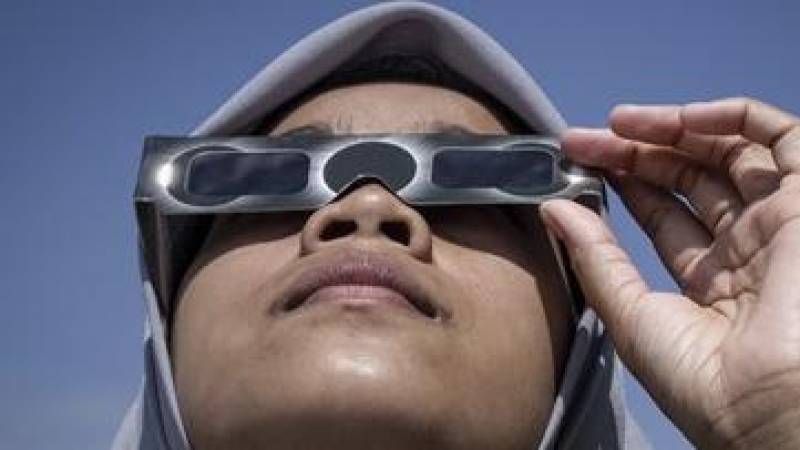 Mujer viendo un eclipse