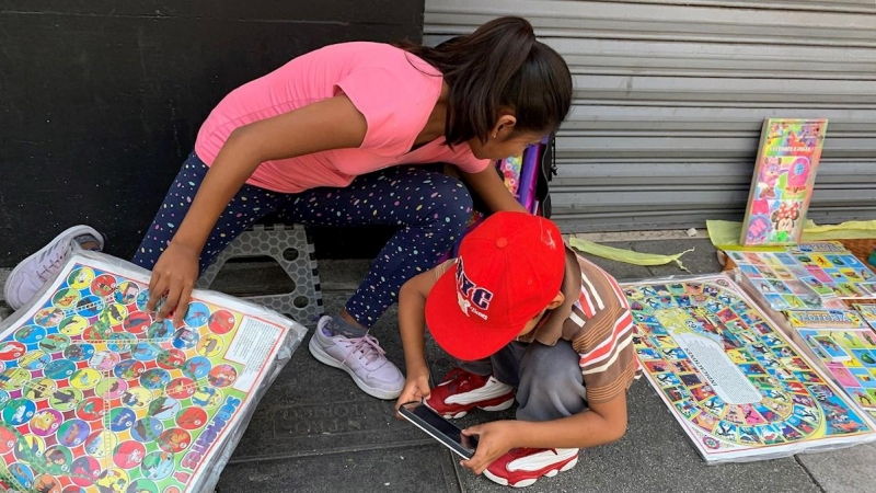 Niños venden juegos de mesa este jueves en una calle del centro histórico de Ciudad de México (México). | EFE