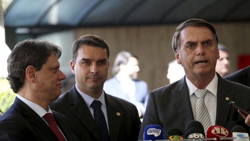 El presidente Jair Bolsonaro y su hijo mayor, el senador Flávio Bolsonaro, junto al ministro de infraestructuras, capitán Tarcísio Gomes de Freitas. WILSON DIAS/ AGÊNCIA BRASIL.