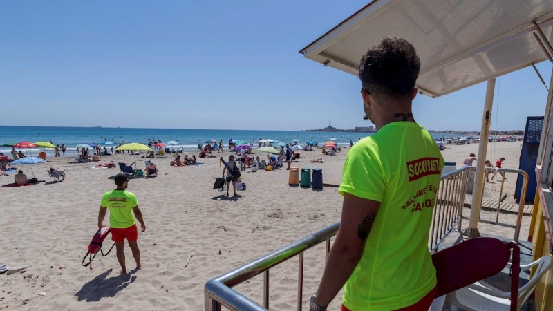 22/06/2020 .- Dos socorristas vigilan a los bañistas que disfrutan del primer día de verano y del primer día de 'nueva normalidad' tras el fin del estado de alarma, este domingo en la playa del Mar Menor. EFE/Marcial Guillén