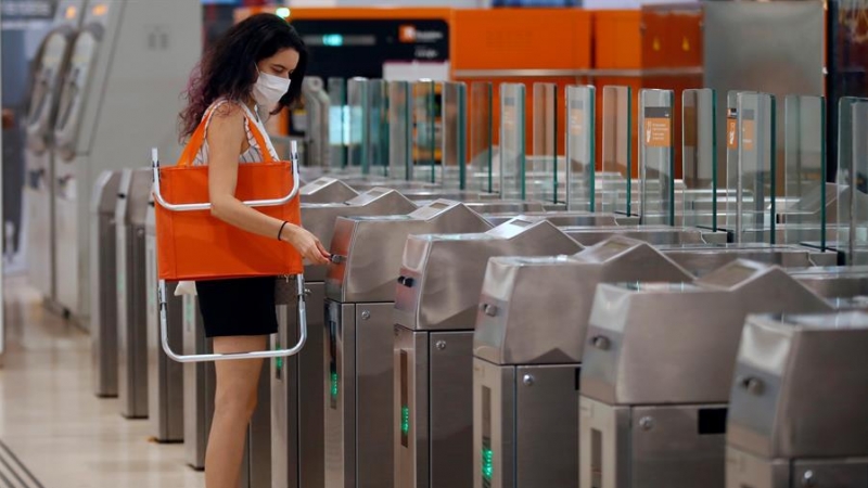 Una joven se dirige a tomar un tren para ira a la playa en la estación de Sants de Barcelona, este sábado segundo día 'nueva normalidad en Cataluña'. / EFE/Toni Albir