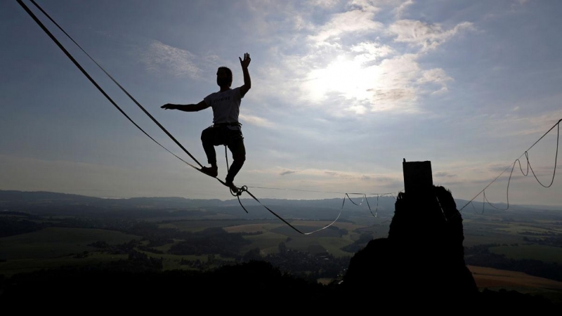 Un participante hace equilibrismo en una cuerda durante un evento de equilibrios en el castillo de Trosky, cerca de la ciudad de Turnov, República Checa. REUTERS / David W Cerny