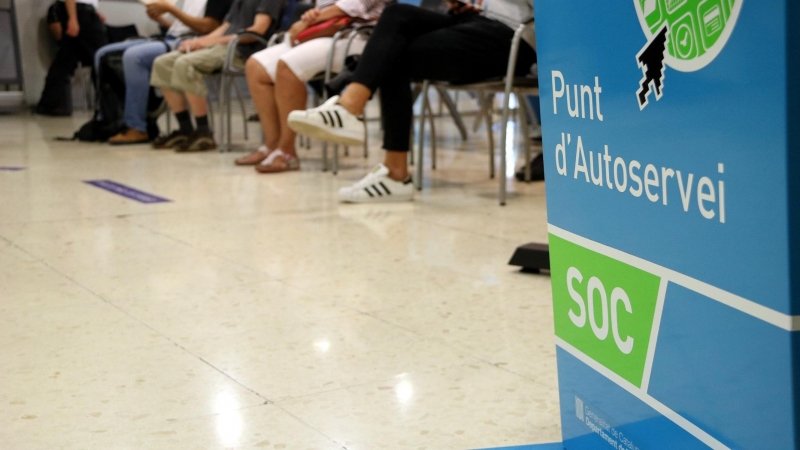 Imatge d'una sala interior d'una oficina del Servei d'Ocupació de Catalunya (SOC) on es veuen els peus d'uns aturats asseguts a la sala d'espera. ANDREA ZAMORANO / ACN