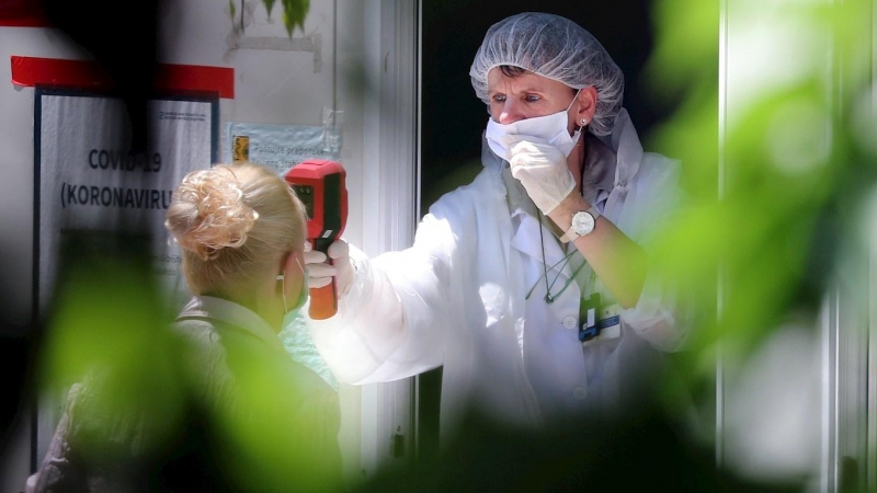 Una trabajadora sanitaria toma la temperatura a una persona. EFE/Archivo