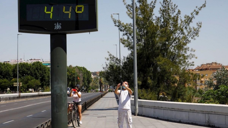 Unas personas fotografían un termómetro de calle en Córdoba que indica 44 grados. EFE/Archivo