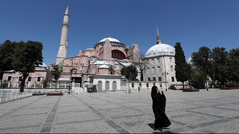 02/07/2020.- Una mujer vestida con un hiyab toma fotografías este jueves frente el Museo de Santa Sofía en Estambul. De acuerdo a los medios locales, un juzgado turco retrasó la decisión acerca de si este edificio declarado por la Unesco Patrimonio de la