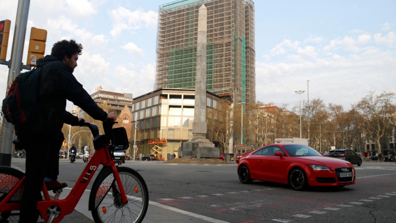 Un home espera creuar en bicicleta el pas de vianants, a tocar de la plaça Cinc d'Oros de Barcelona. ACN/Blanca Blay