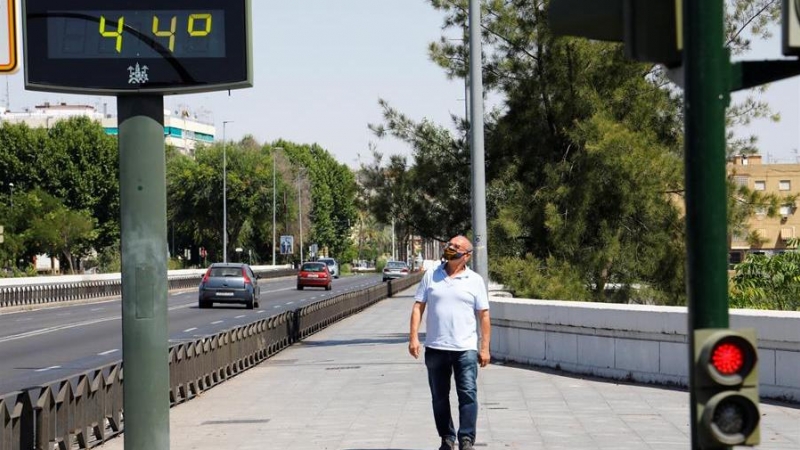 Un hombre camina junto a un termómetro con 44 grados ayer en Córdoba. EFE/Salas