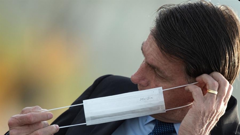 El presidente de Brasil, Jair Bolsonaro, se pone una mascarilla durante una ceremonia oficial, el 9 de junio de 2020, en el Palacio do Alvorada. EFE/ Joédson Alves.