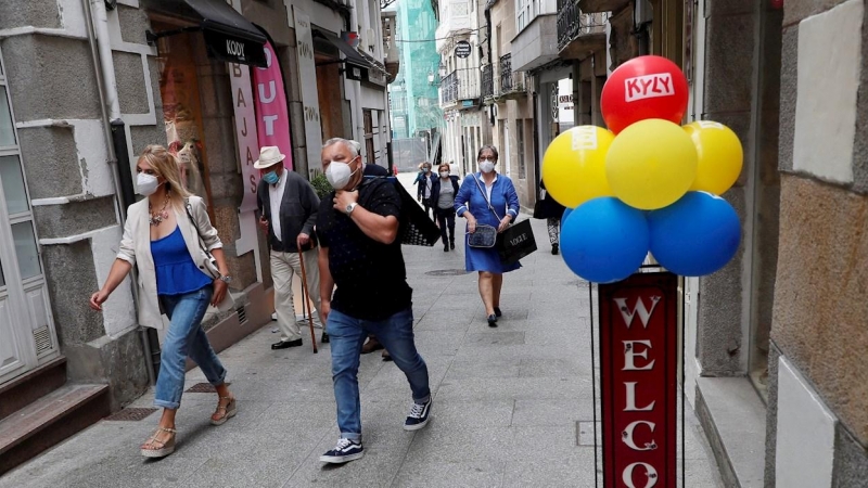 Varias personas con mascarilla caminan por la calle de Viviero, Lugo este martes.  | EFE