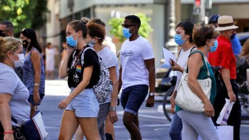 Personas en la calle con mascarilla / EFE