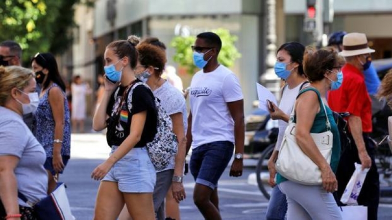 Personas en la calle con mascarilla / EFE