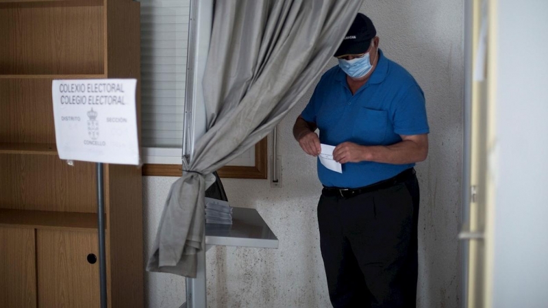 Un hombre coge una papeleta antes de votar en un colegio electoral de Requiás, Muiños (Ourense), este domingo con motivo de las elecciones autonómicas. EFE/ Brais Lorenzo