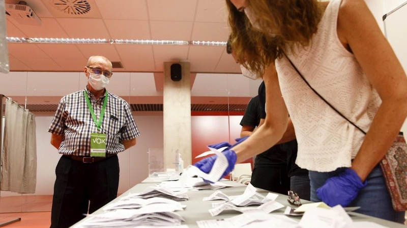 Un interventor de Vox (i), observa el recuento de los sufragios en una mesa de un colegio de Vitoria, al término de la jornada electoral de este domingo. EFE/ David Aguilar